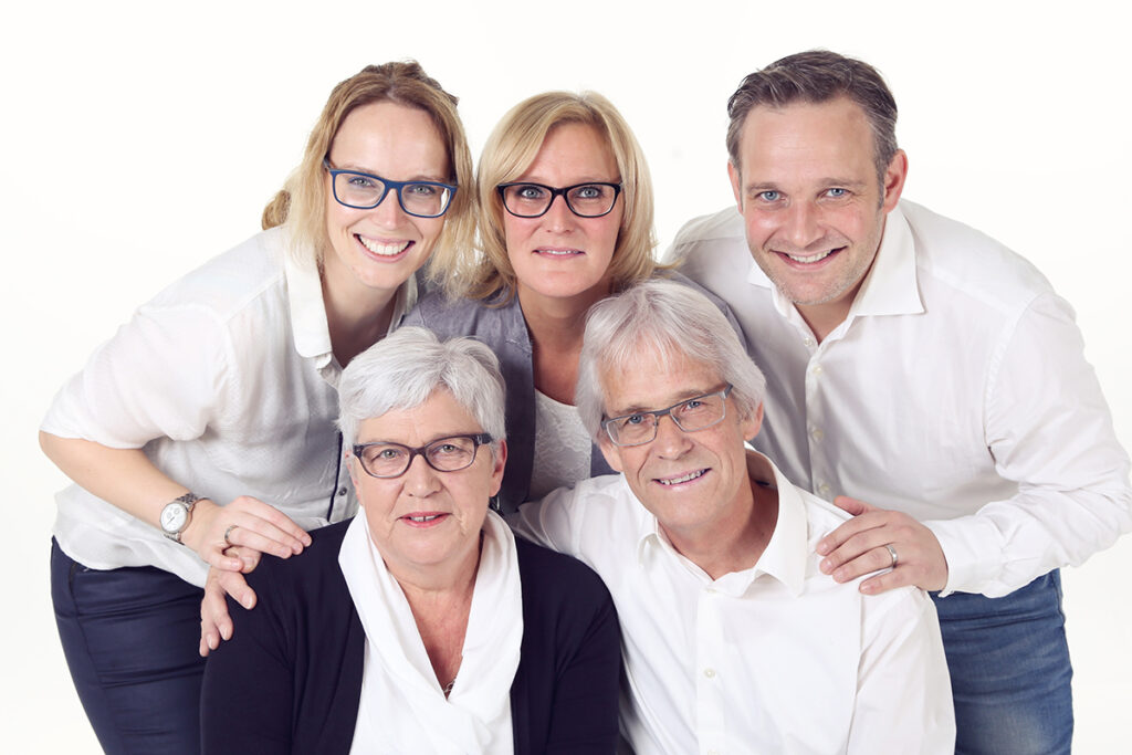 Drie generaties familie lachend samen in de witte studio
