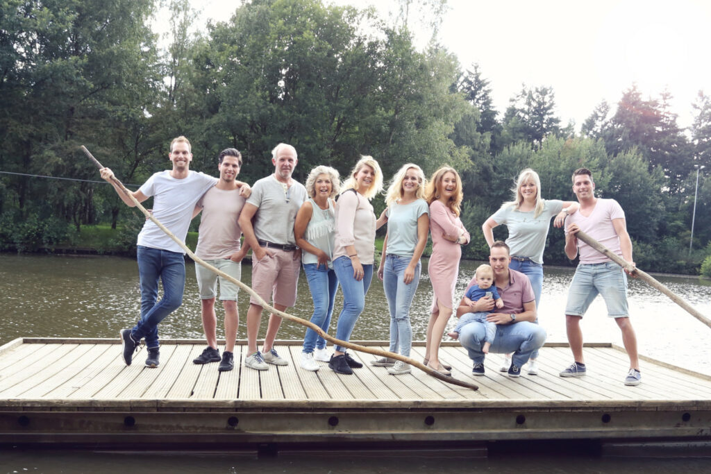 Grote familie op een steiger aan het water, familieshoot buiten