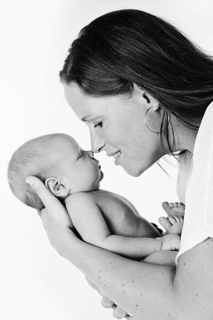 Zwart-witfoto van moeder en newborn neus aan neus