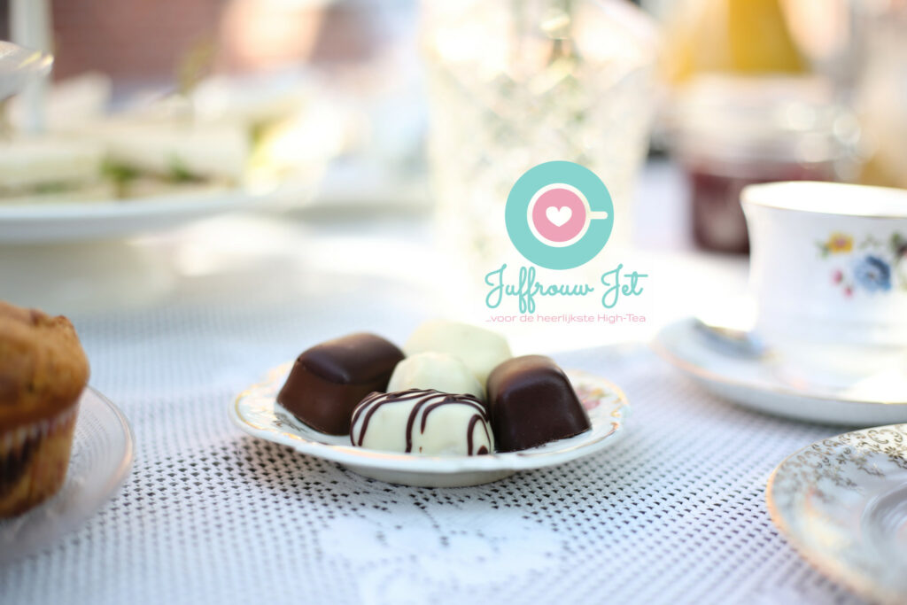 Bonbons op een schoteltje naast een kopje thee