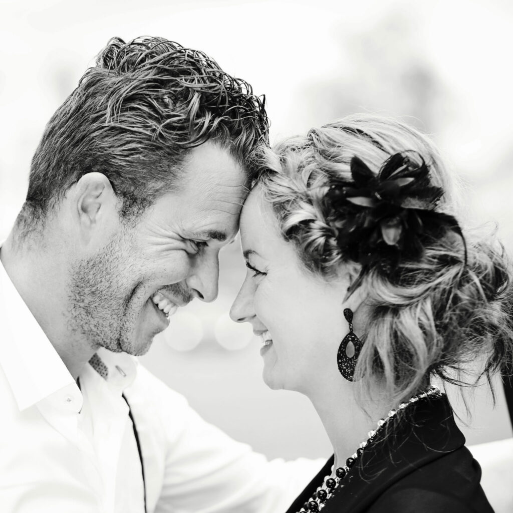 Zwart-witfoto van een stel dat elkaar lachend aankijkt tijdens een loveshoot