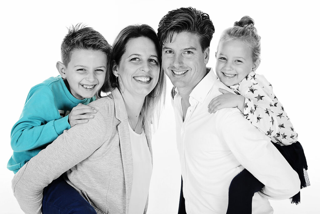 Ouders met zoon en dochter lachend samen in de witte studio