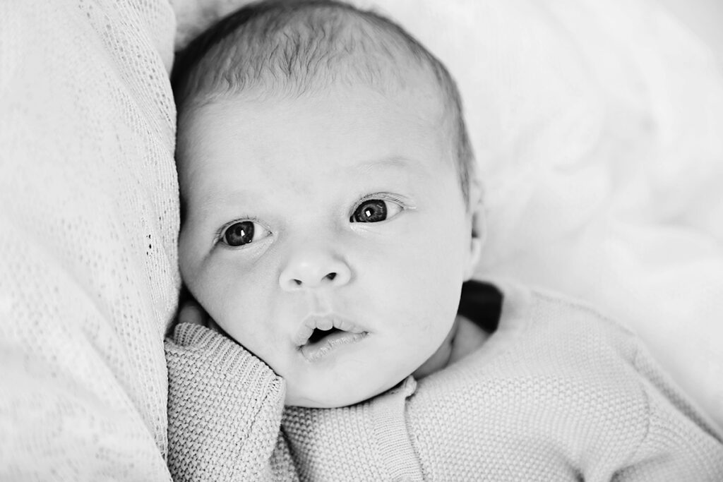 Zwart-witfoto van een wakkere newborn met grote ogen