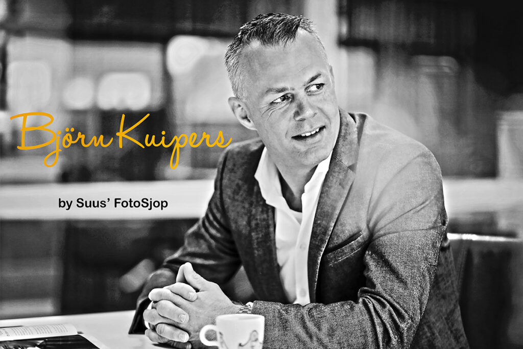 Zwart-witportret van een man aan een tafel, portret voor een bekende Nederlander
