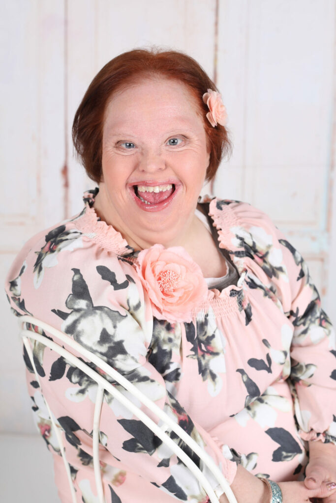 Lachende vrouw in bloemenblouse, portret voor een goed doel