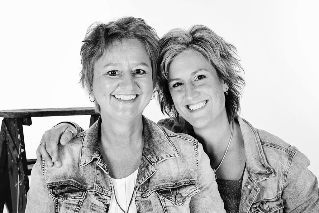 Moeder en dochter in spijkerjasjes lachend samen op de foto