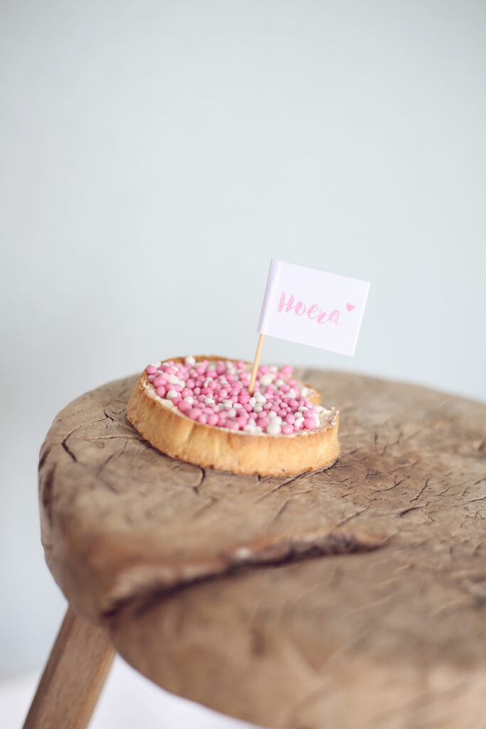 Beschuit met muisjes op een houten krukje, newborn detail
