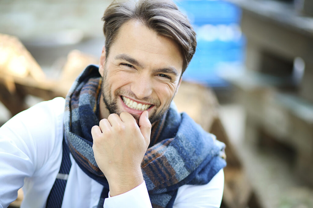 Lachende man met sjaal in de stad, modelportret
