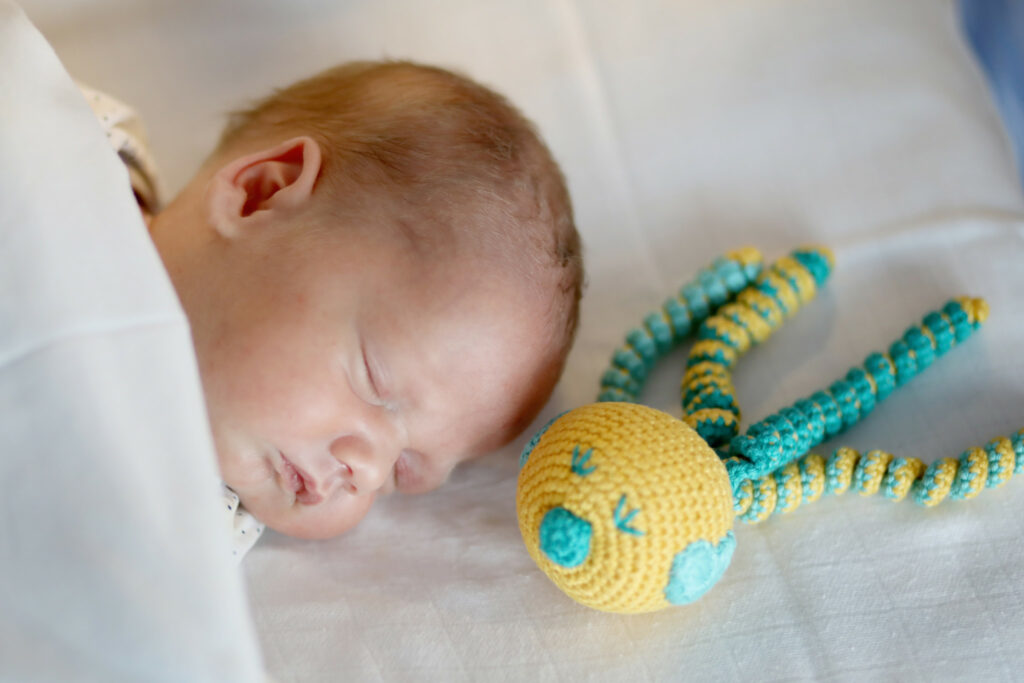 Slapende baby met een gehaakte octopus, foto voor een goed doel