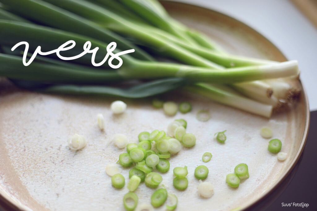 Lente-uitjes en doperwten op een bord met het woord 'vers', foodfotografie