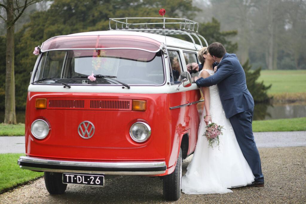 Bruidspaar bij een rode Volkswagenbus, trouwfotografie