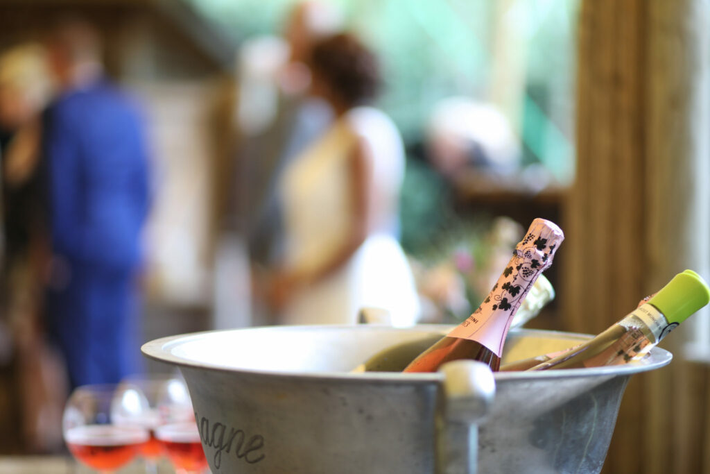 Champagne in een ijsemmer met gasten op de achtergrond, bruiloft