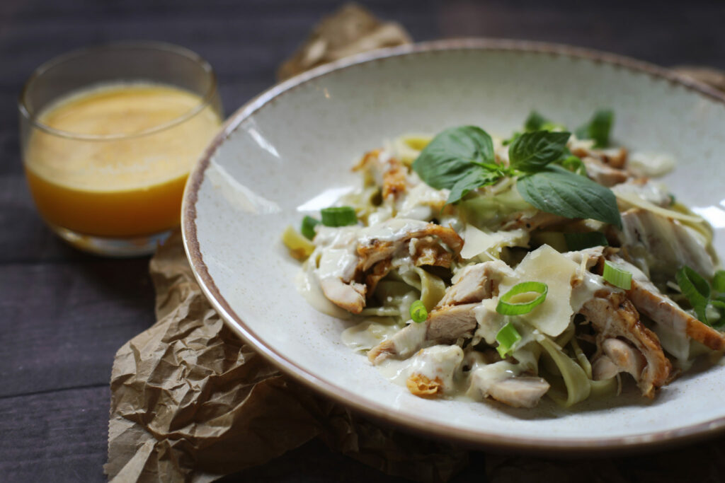 Salade met paddenstoelen op een bord naast een glas sap, foodfotografie