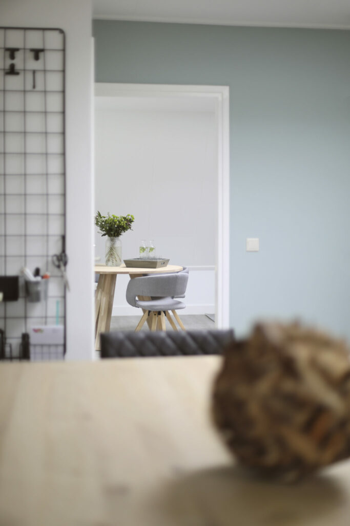 Doorkijk naar de eethoek met decoratiebal op de voorgrond, sfeerfoto interieur