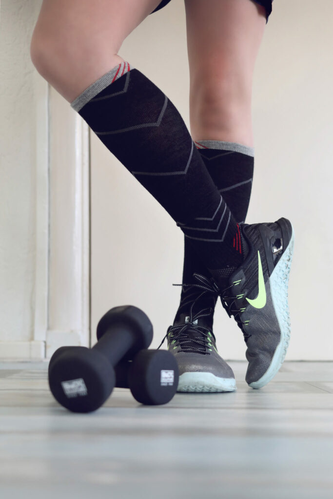 Sportsokken en sneakers naast een dumbbell, productfoto