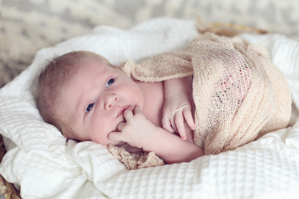 Newborn ligt op een zachte witte deken, newborn fotografie