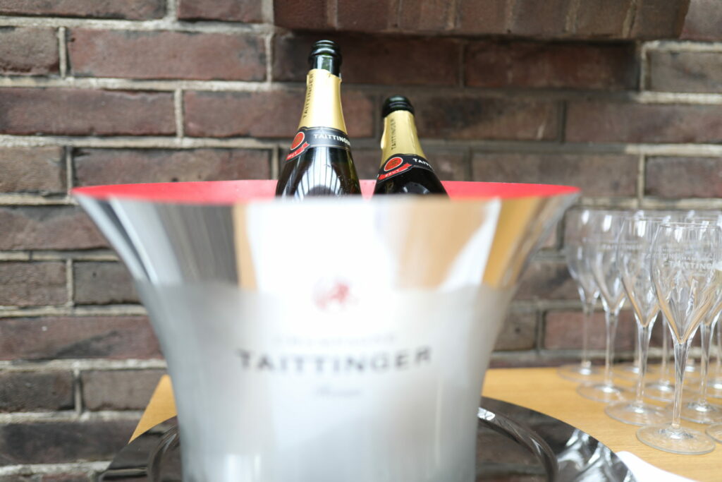 Champagne in een zilveren koeler voor een bakstenen muur
