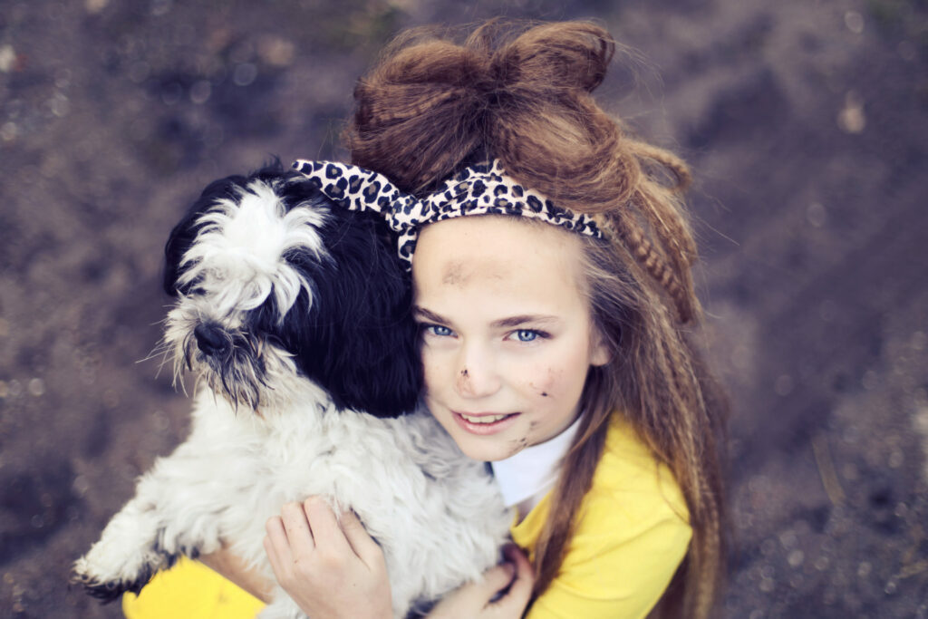Vrouw met strik in het haar knuffelt haar zwart-witte hondje