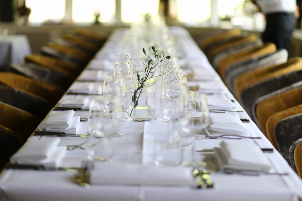 Lange gedekte tafel met glazen voor het bruiloftsdiner