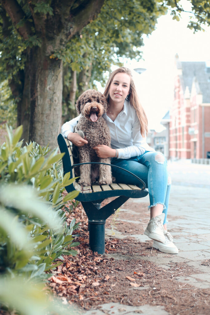 Vrouw met haar kleine hond op een bankje in het park