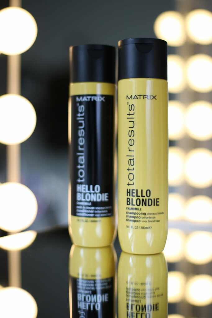 Twee flessen shampoo met lampjes op de achtergrond, productfotografie
