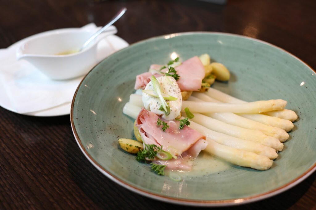 Asperges met ham op een groen bord, sfeervolle foodfoto