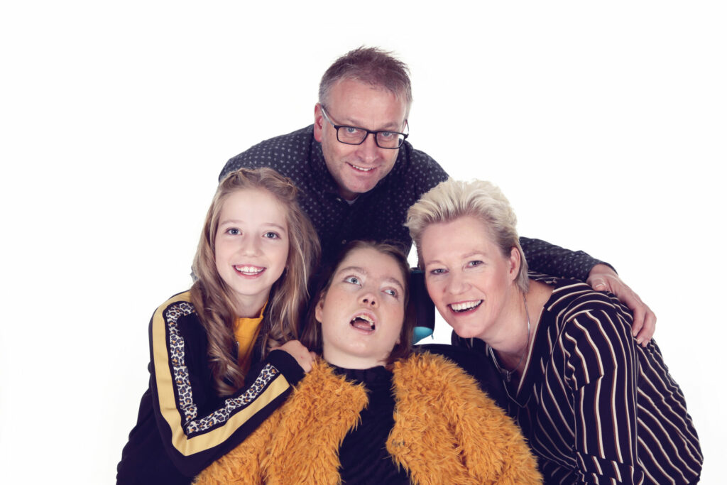 Ouders met twee tieners lachend samen in de witte studio