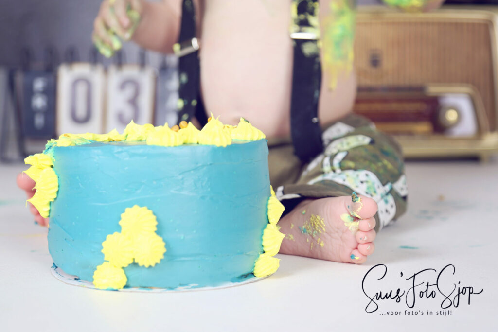 Blauwe verjaardagstaart met gele bloemetjes bij een cakesmash in de studio
