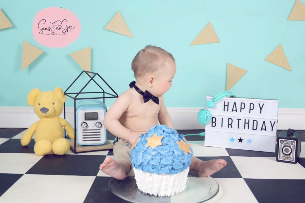 Jongetje met blauwe taart en bord 'Happy birthday' bij een cakesmash in de studio