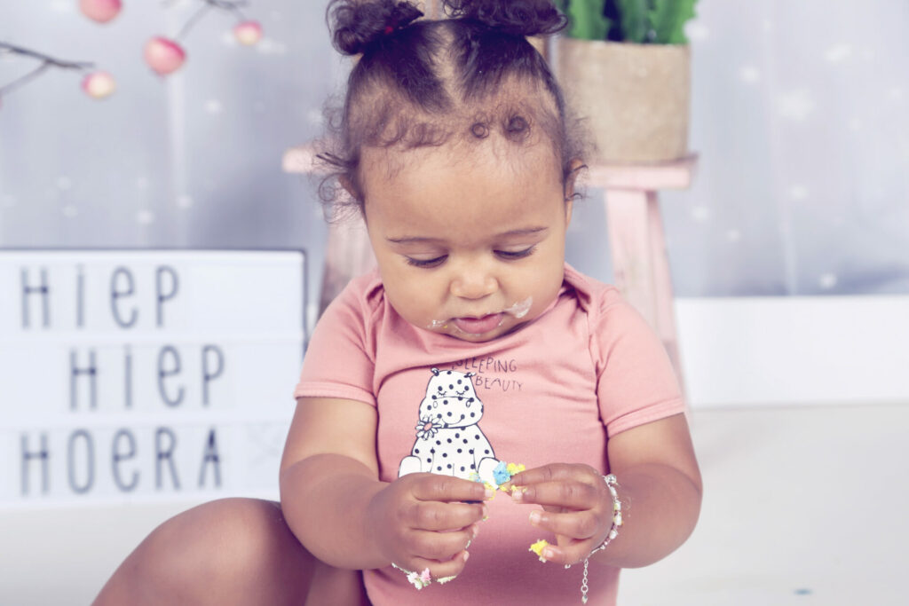 Babymeisje met taart en bord 'Hiep hiep hoera', cakesmash in de studio