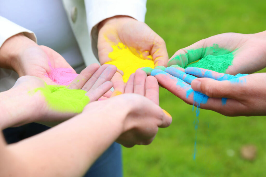 Handen vol gekleurd poeder in geel, groen en blauw, ColorPowder-shoot