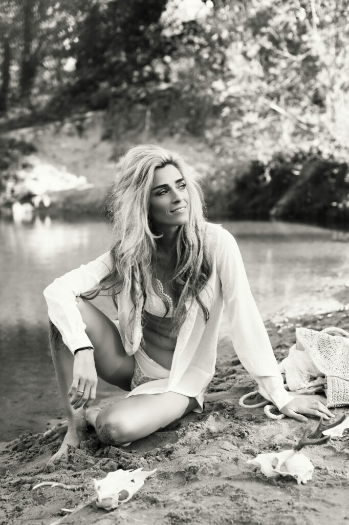 Zwart-witfoto van een blonde vrouw in het gras, fashion fotografie