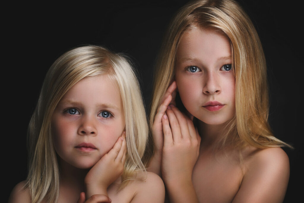 Twee blonde zusjes samen tegen een donkere achtergrond, Pure Portrait