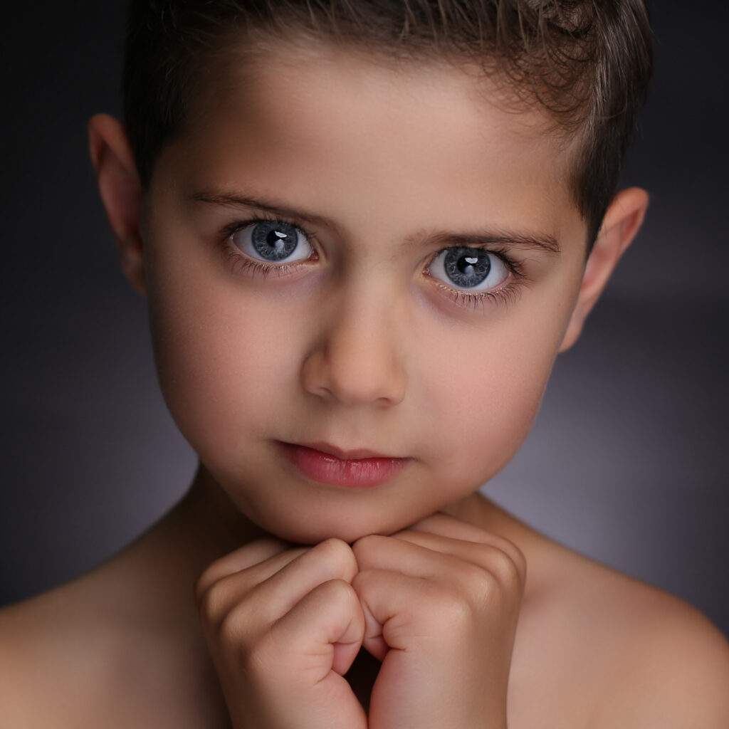 Jongen met blauwe ogen en handen onder de kin, Pure Portrait