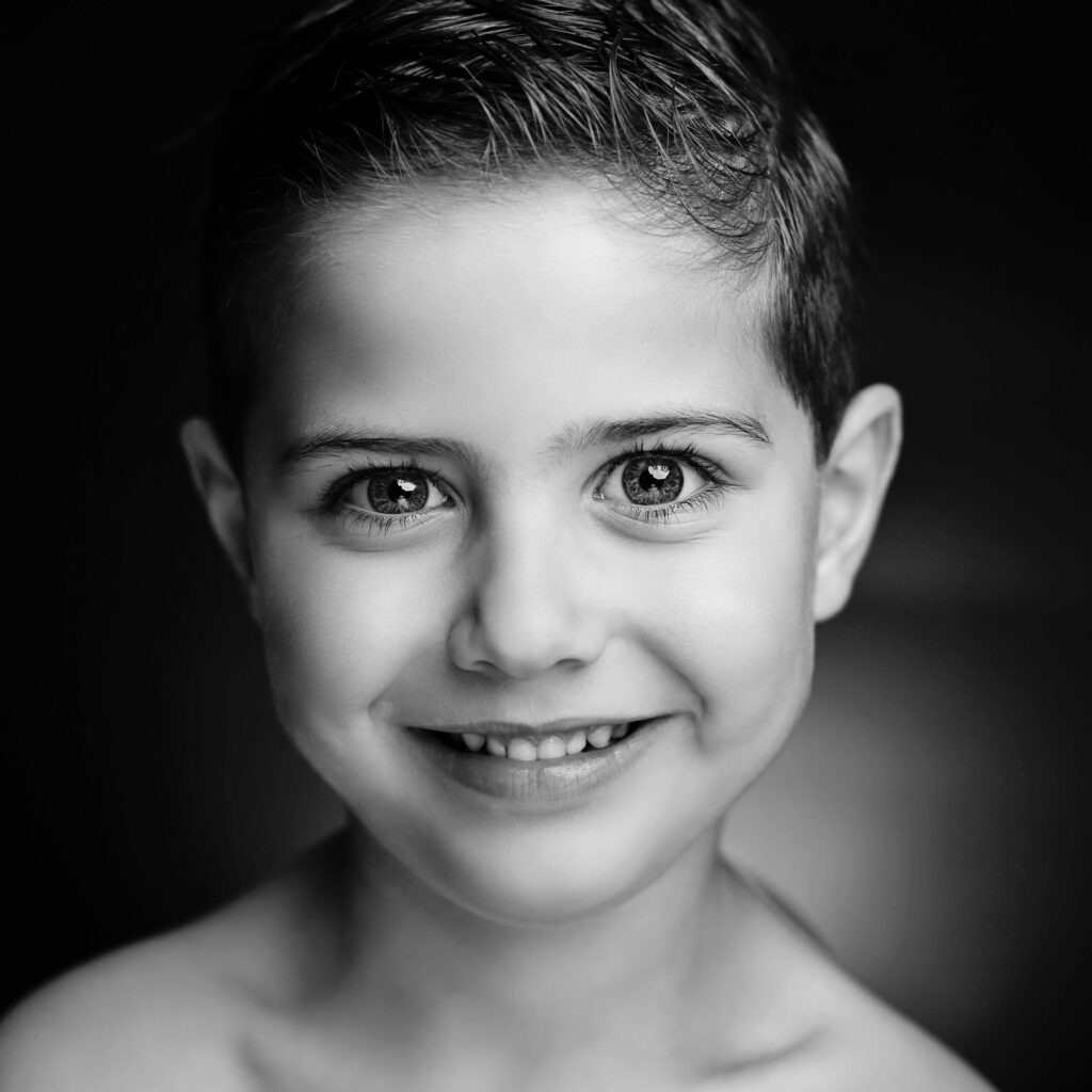 Zwart-witportret van een lachende jongen van dichtbij