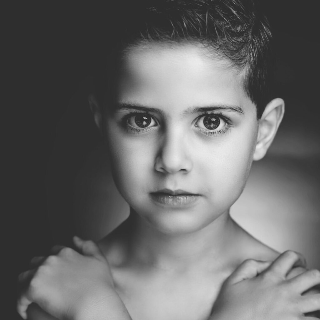 Zwart-witportret van een jongen met de armen over elkaar