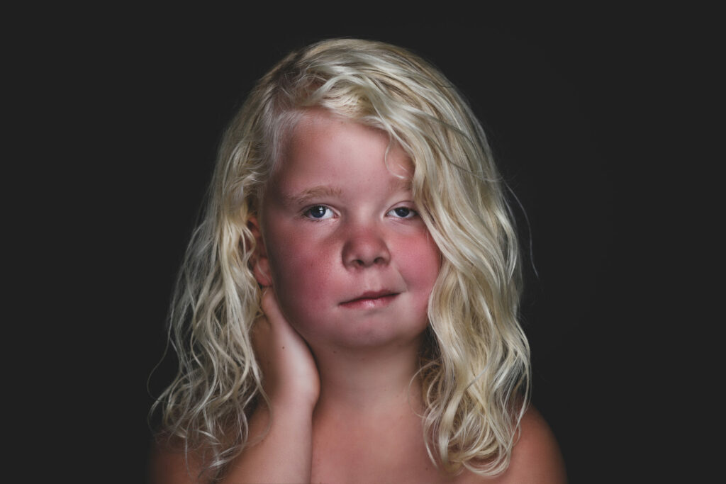 Meisje met blonde krullen en handen aan haar wangen, Pure Portrait