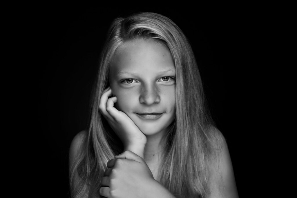 Zwart-witportret van een meisje met lang haar en sproetjes