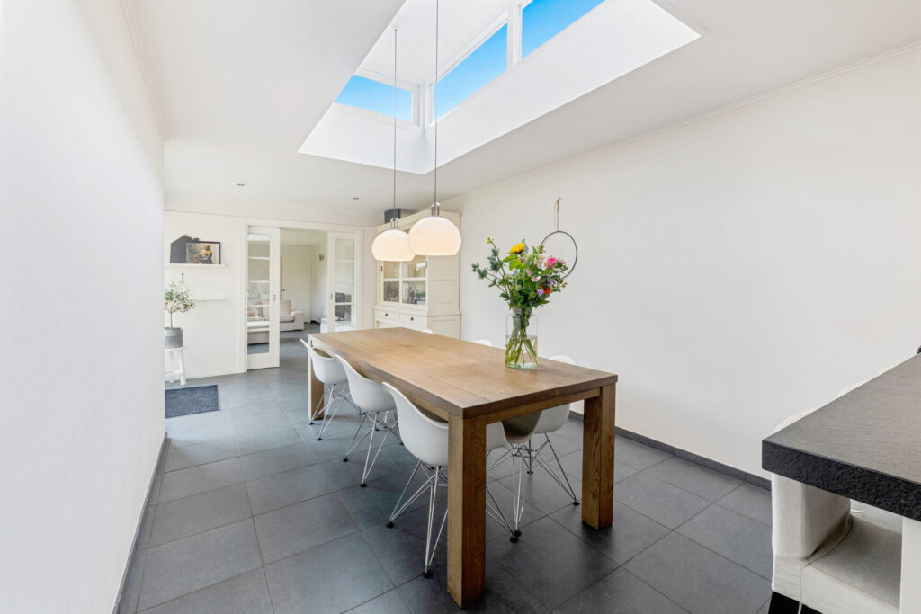 Lange eethoek met houten tafel en daklicht, vastgoedfotografie