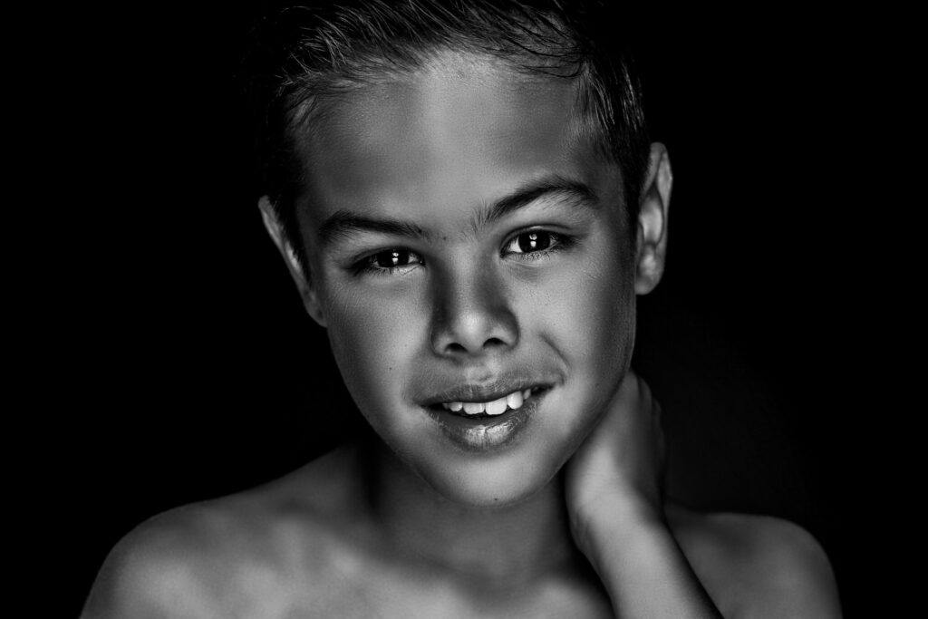 Zwart-witportret van een jongen met de hand in zijn nek