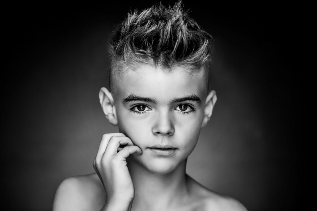 Zwart-witportret van een jongen met stoer kapsel
