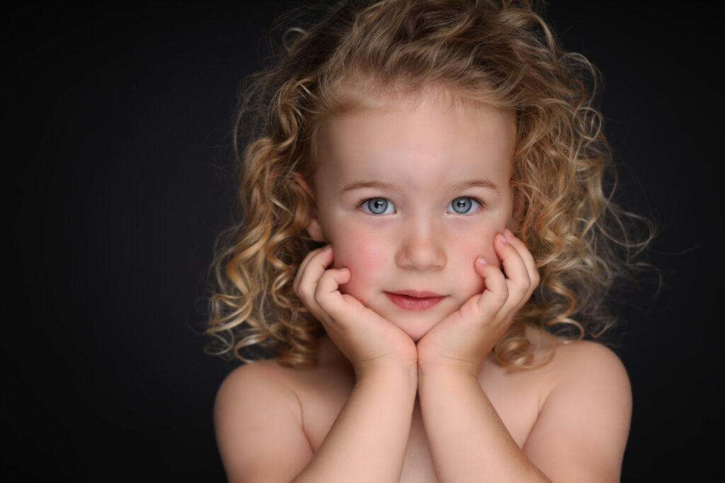 Meisje met blonde krullen en handen onder de kin, Pure Portrait