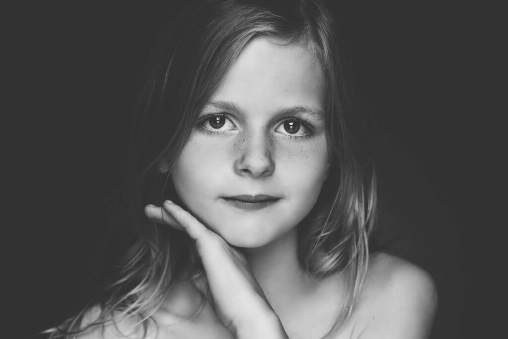 Zwart-witportret van een meisje met de hand onder haar kin