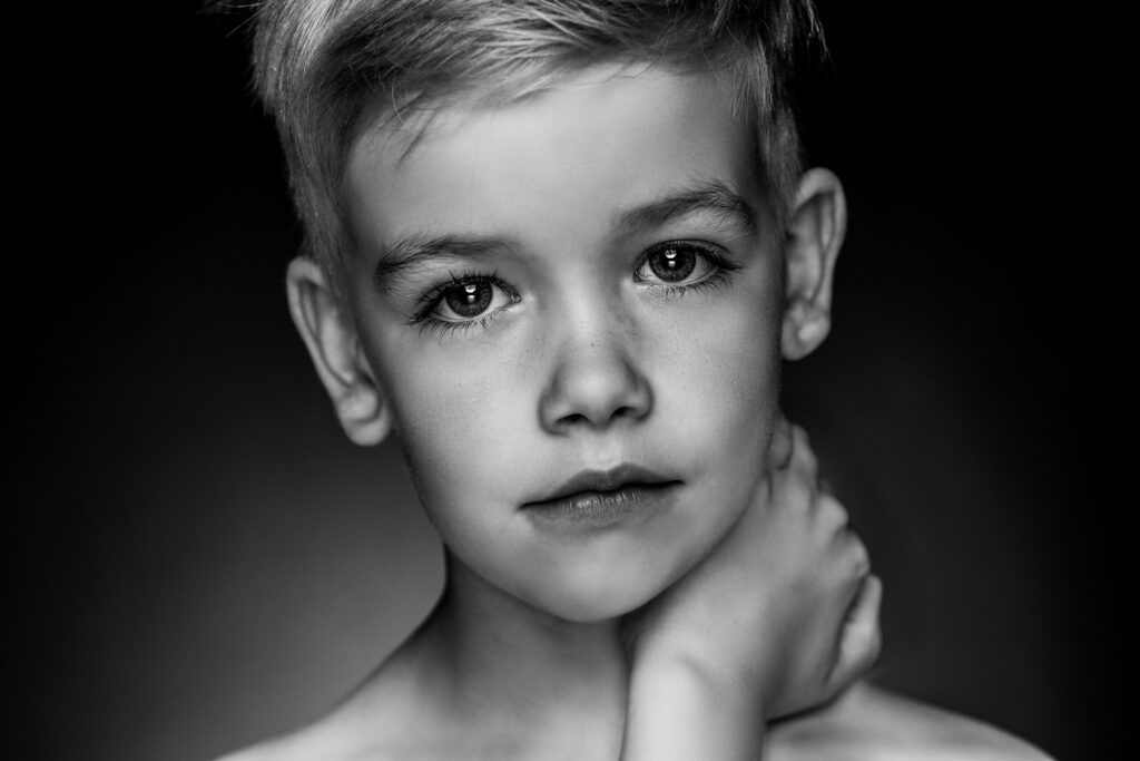 Zwart-witportret van een jongen met de hand aan zijn gezicht