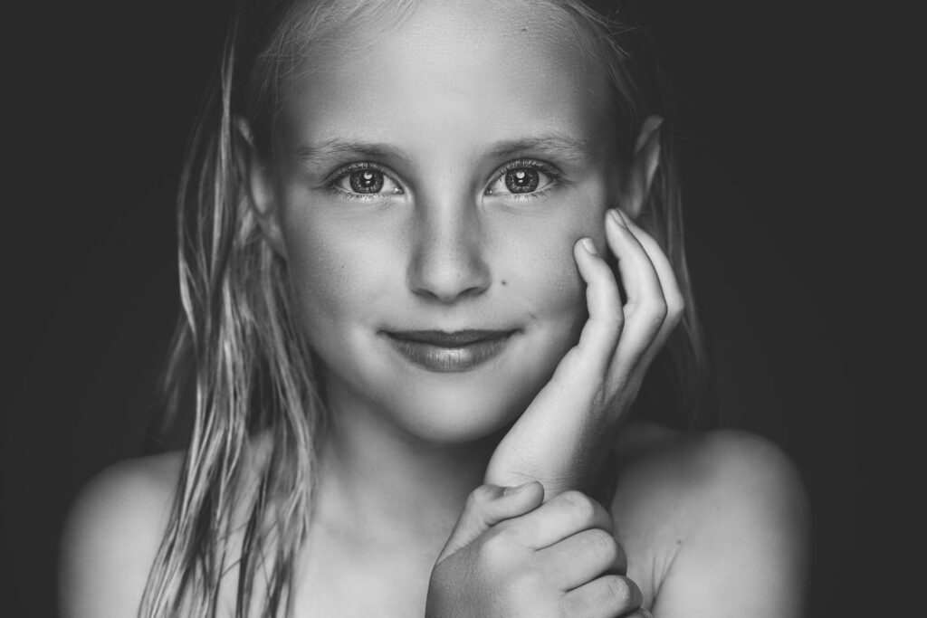 Zwart-witportret van een glimlachend meisje met lang haar