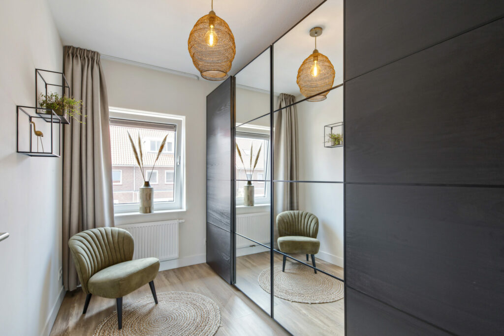 Slaapkamer met spiegelkast, fauteuil en hanglampen