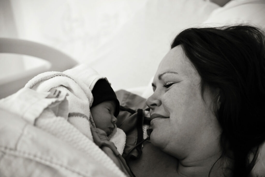Zwart-witfoto van moeder die haar pasgeboren baby voor het eerst knuffelt