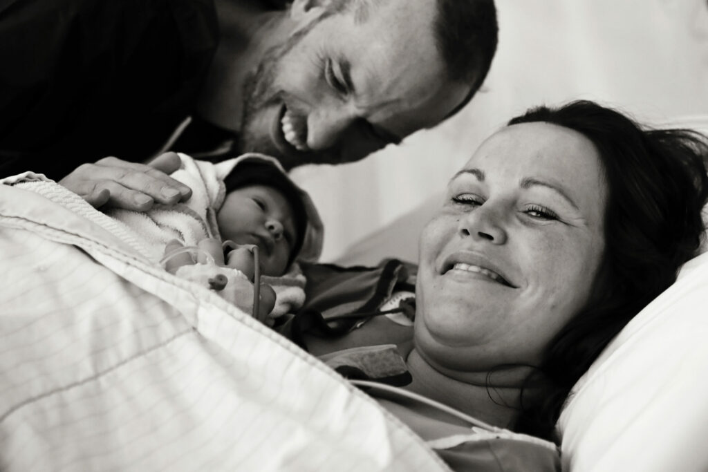 Zwart-witfoto van ontroerde ouders met hun pasgeboren baby