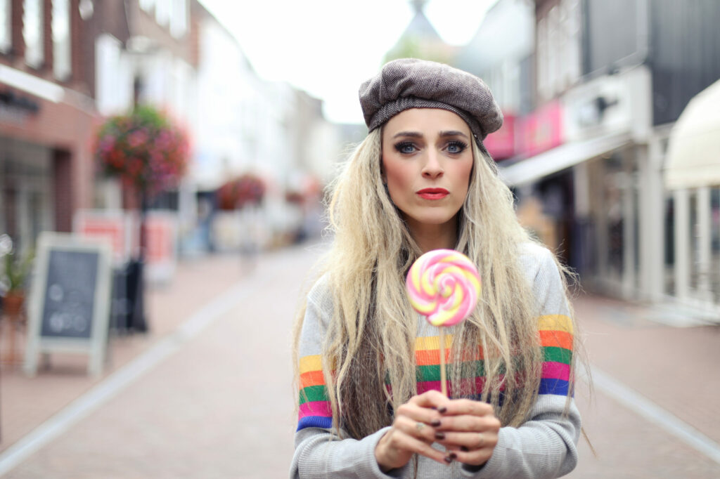 Vrouw met baret en lolly in een winkelstraat