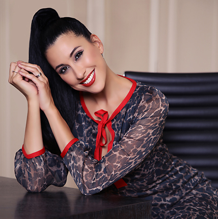 Lachende vrouw in gebloemde jurk aan een tafel, fashion portret